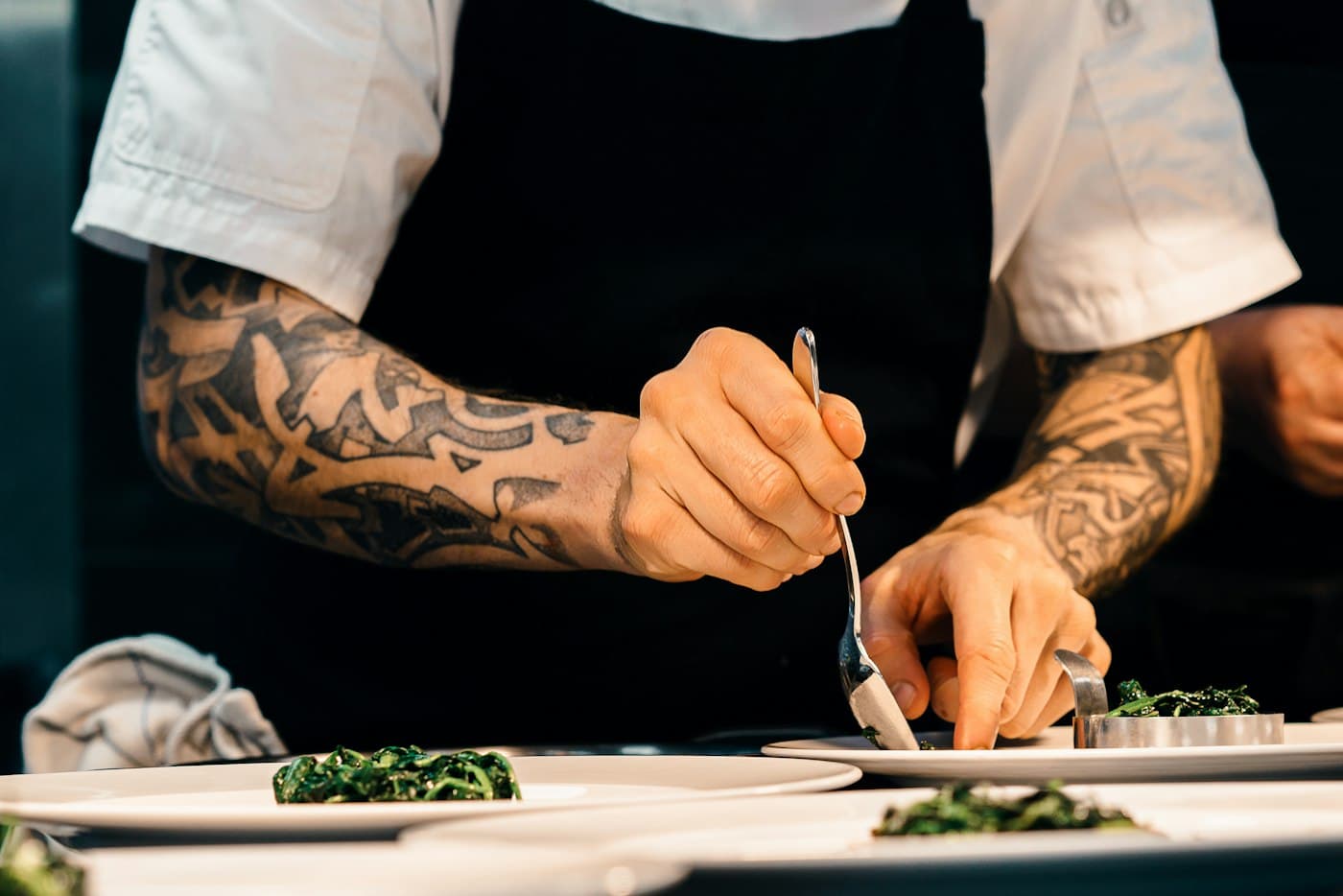 Mains d’un chef dressant une assiette