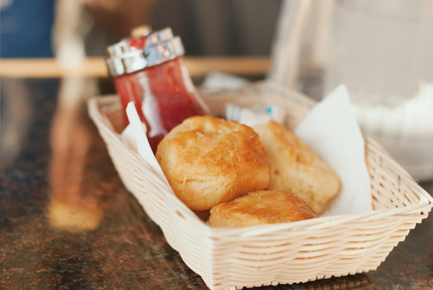 Panier de pain frais et pots de confiture sur une table